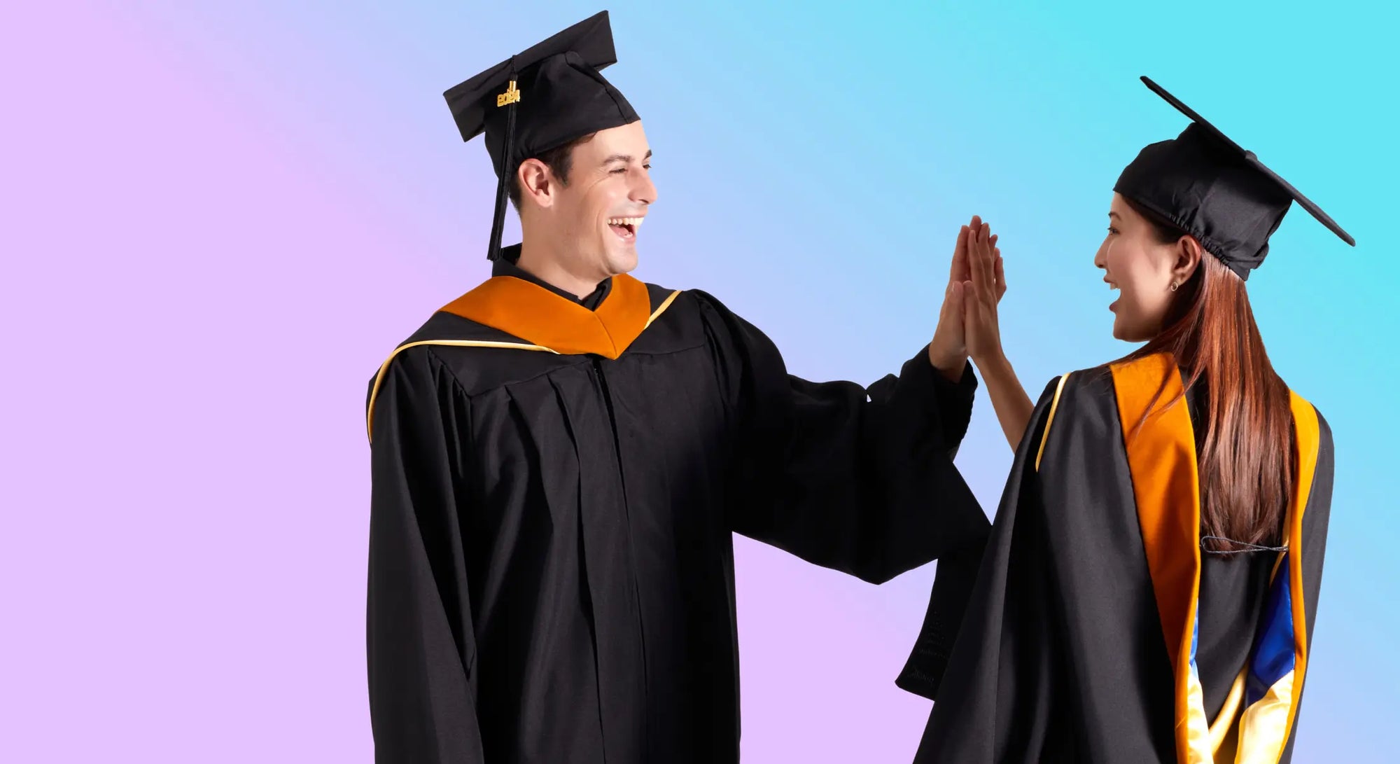 Male and female Master's graduates wearing gowns, caps and hoods celebrate graduation with a high five.