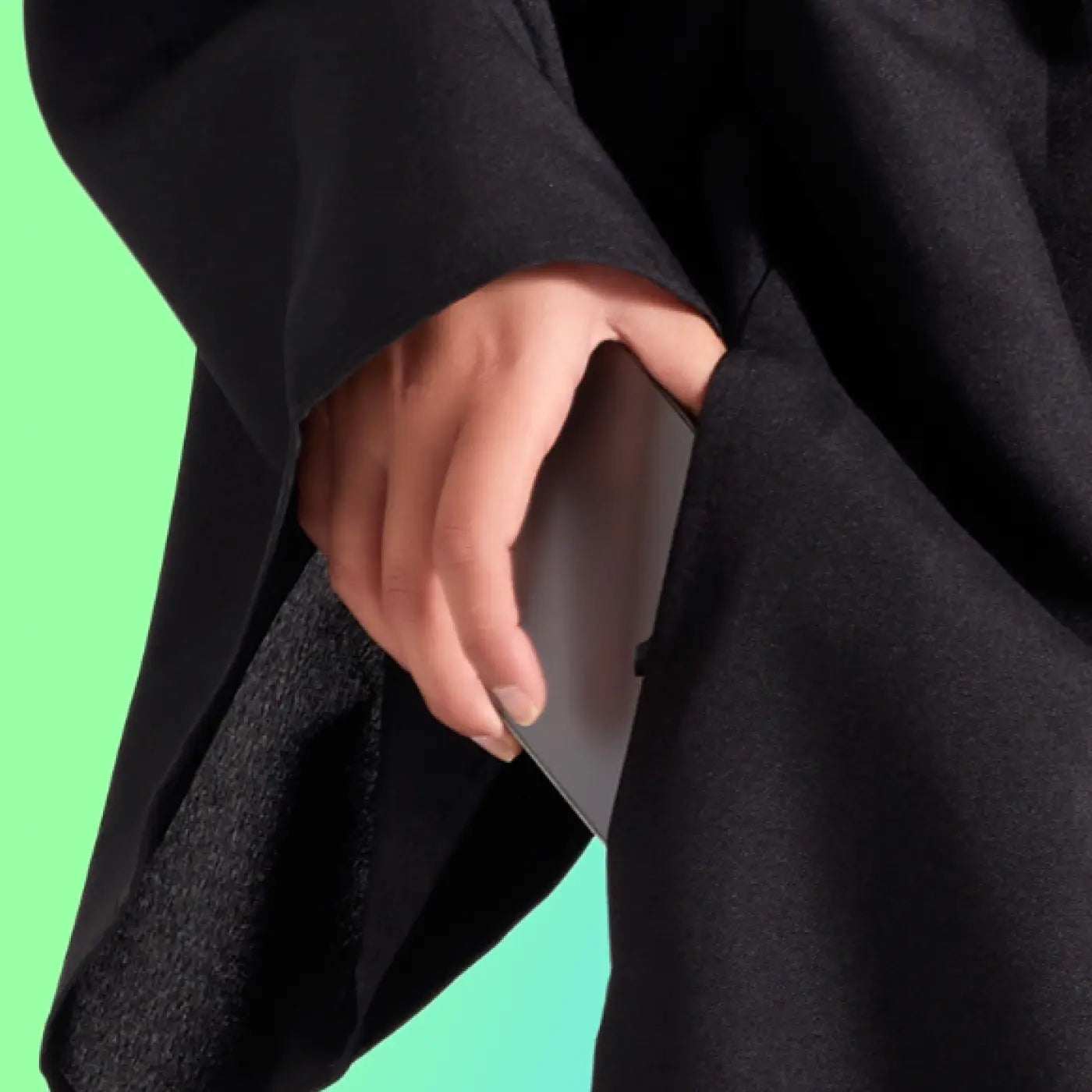 Student putting a phone into the pocket of a graduation regalia robe