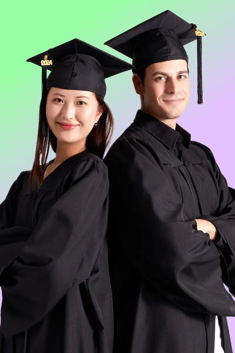 Male and female graduates standing back to back wearing gowns and caps looking happy