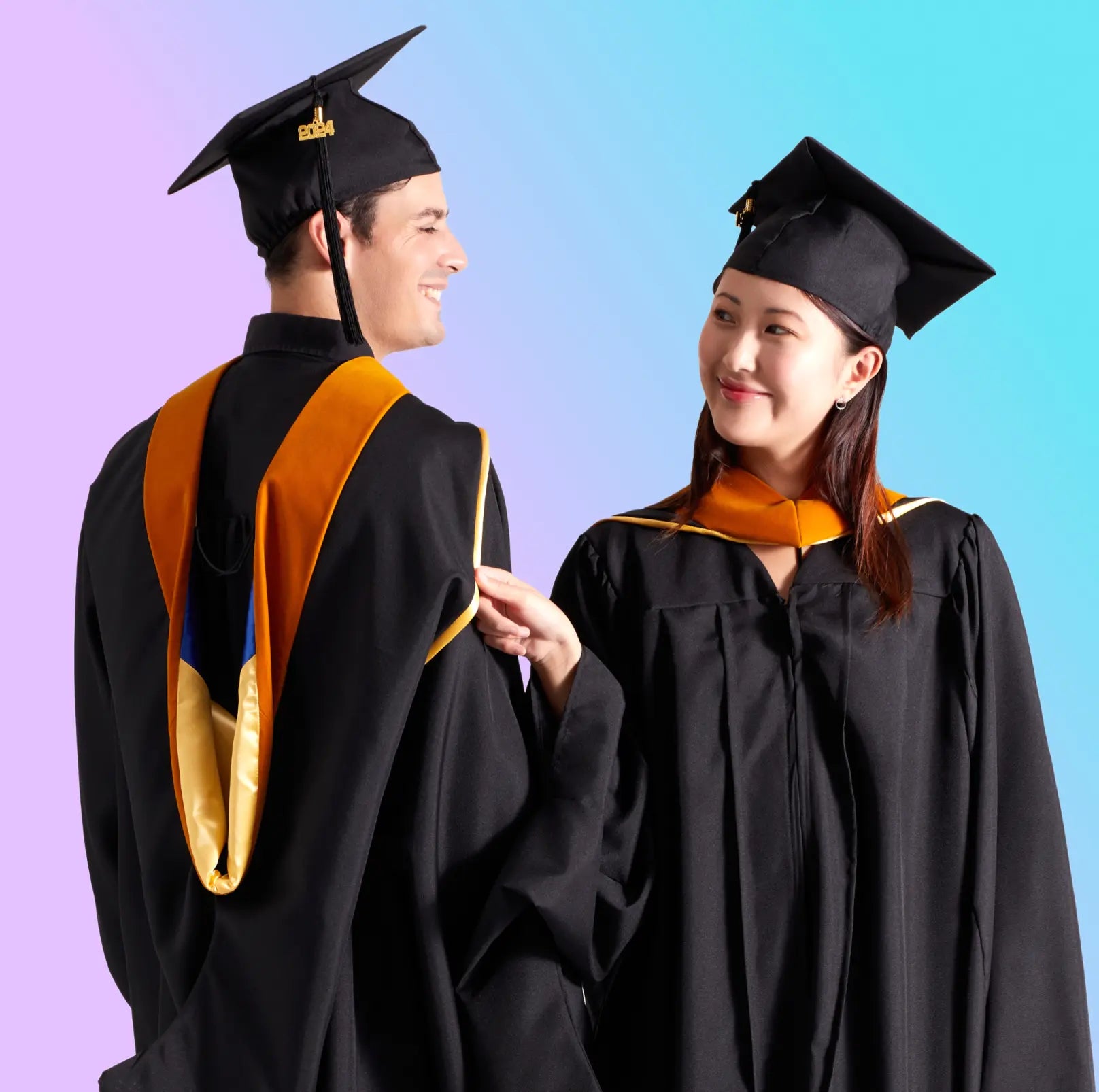 Male and female Master's graduates wearing masters regalia with hoods on graduation day